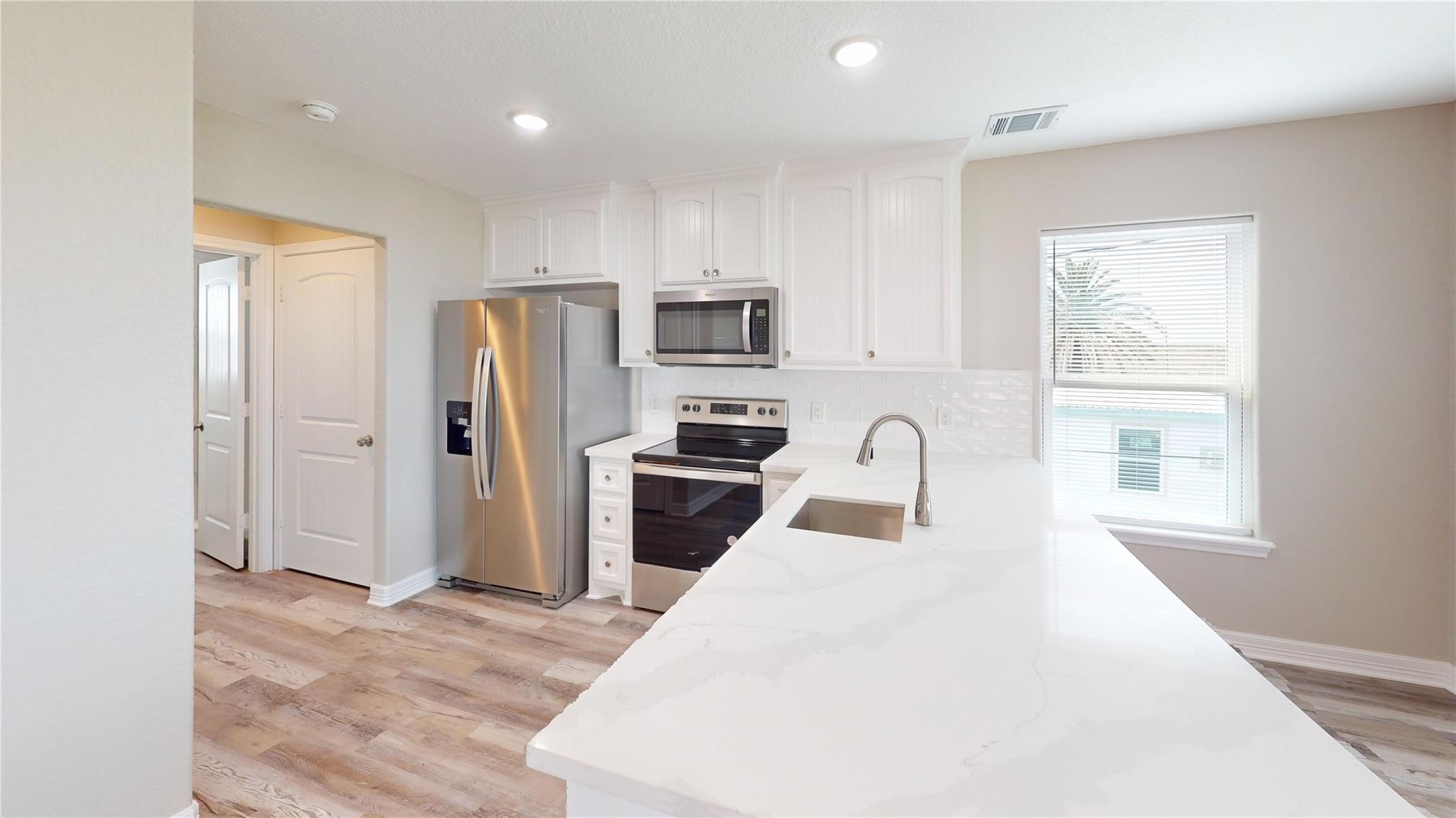 511 Caisson Street Surfside Beach, TX 77541 - Photo 10 of 33 a kitchen with granite countertop a refrigerator and a stove top oven