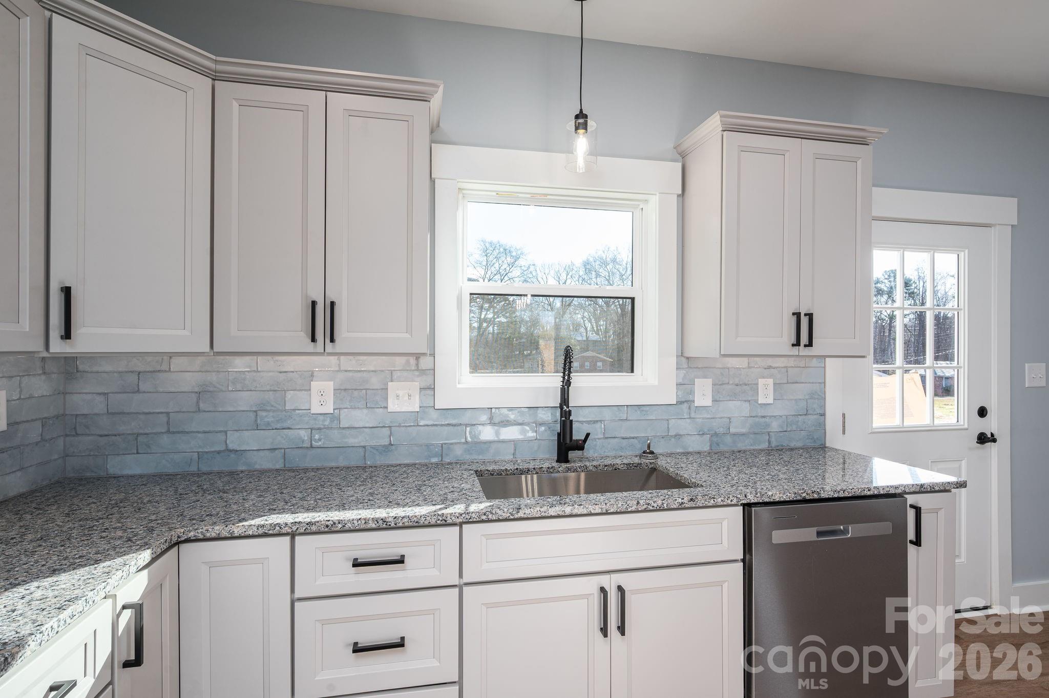 1161 13th Street Southwest Hickory, NC 28602 - Photo 12 of 27 a kitchen with granite countertop white cabinets and a sink