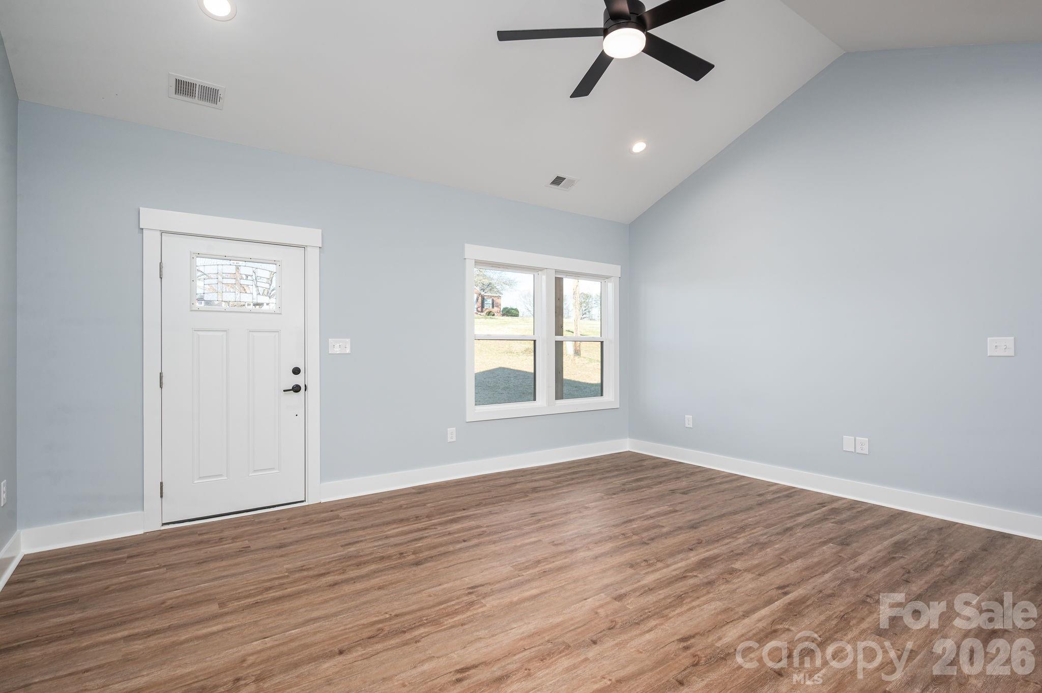1161 13th Street Southwest Hickory, NC 28602 - Photo 4 of 27 an empty room with wooden floor ceiling fan and window