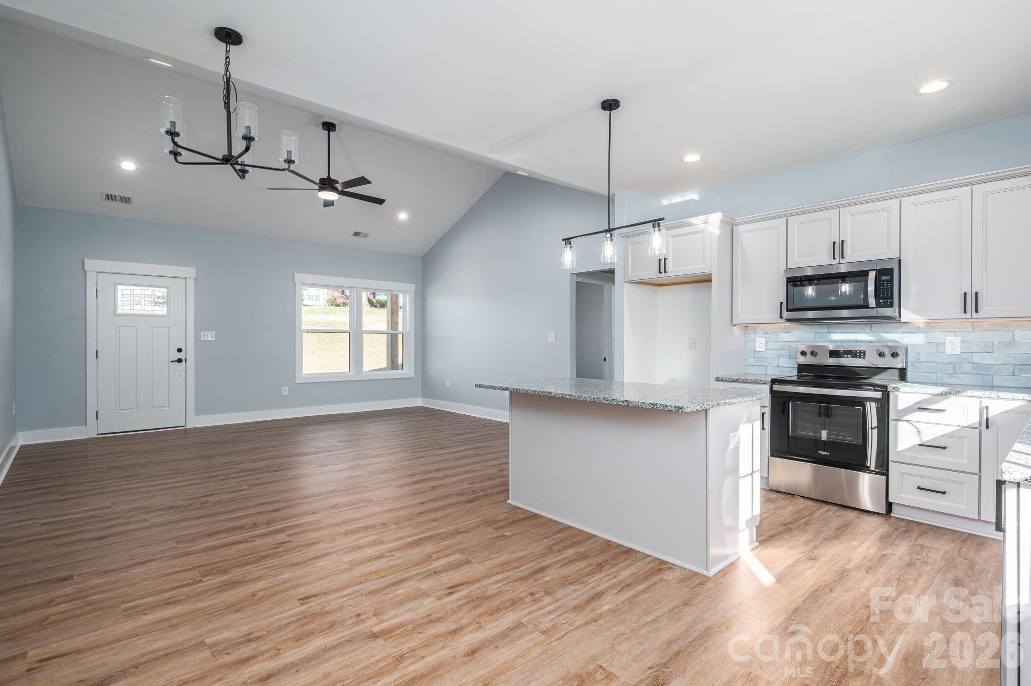 1161 13th Street Southwest Hickory, NC 28602 - Photo 8 of 27 a kitchen with kitchen island granite countertop stainless steel appliances cabinets a sink and a wooden floor