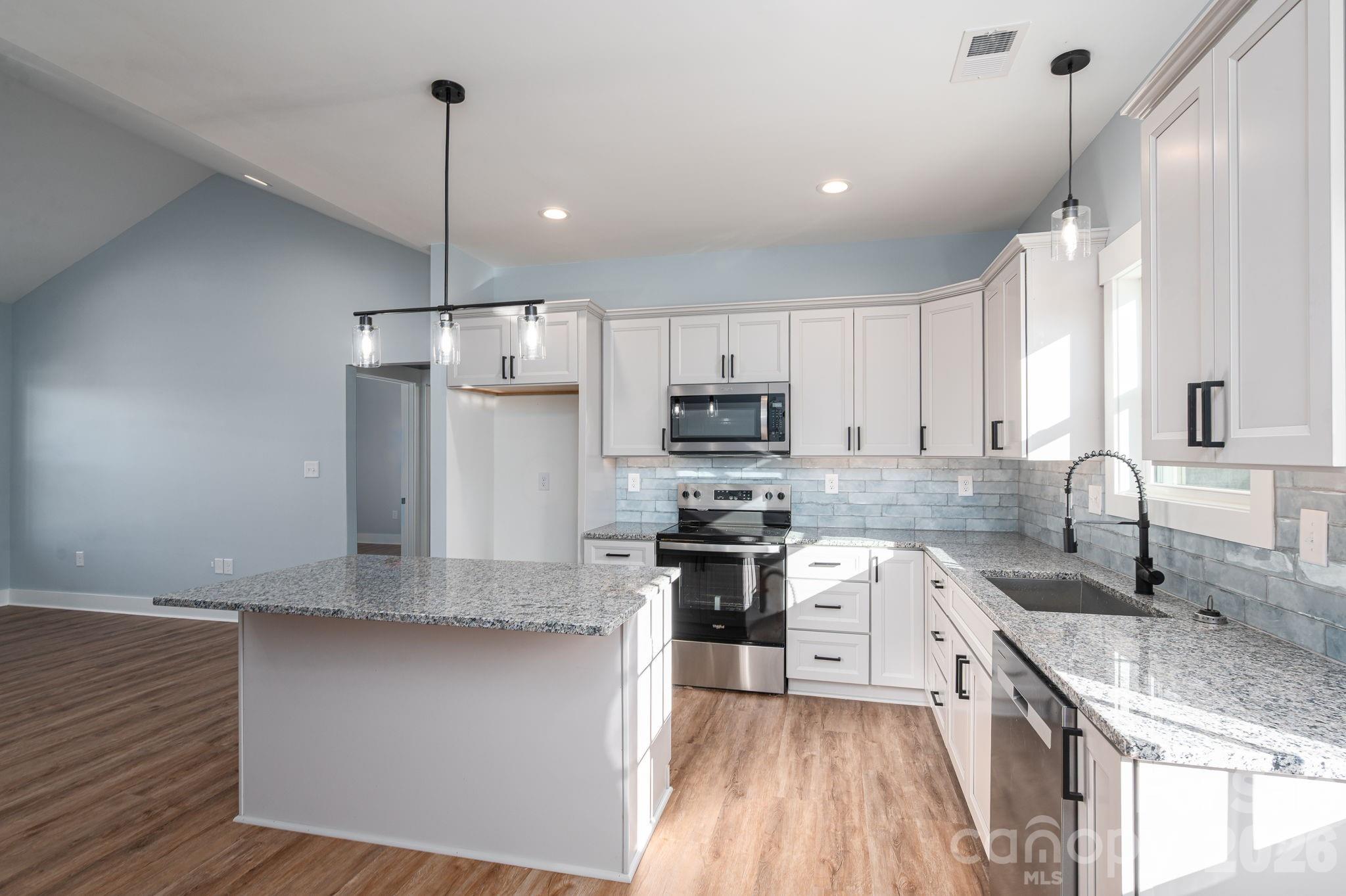 1161 13th Street Southwest Hickory, NC 28602 - Photo 9 of 27 a kitchen with stainless steel appliances granite countertop a sink a stove and a refrigerator
