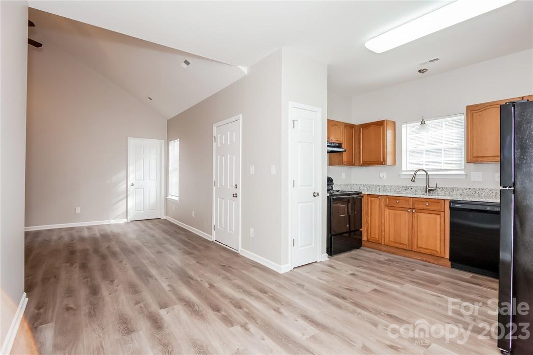 8215 Pozzi Road Charlotte, NC 28216 - Photo 4 of 15 a kitchen with stainless steel appliances kitchen island granite countertop a stove a sink and a refrigerator