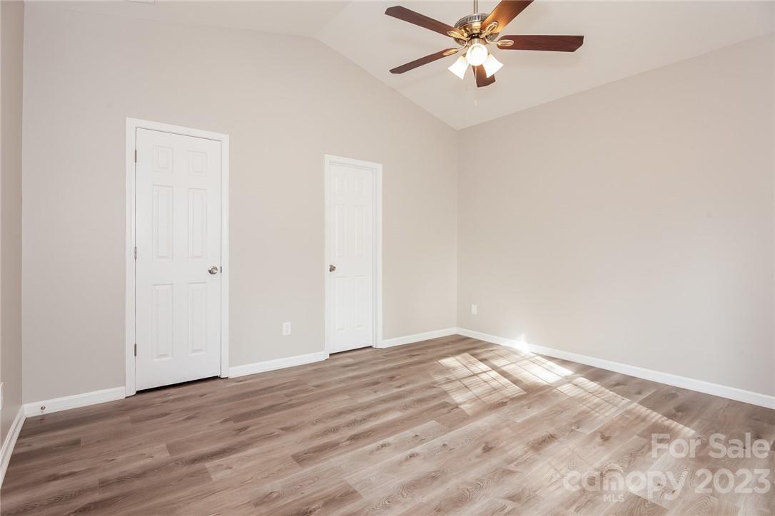 8215 Pozzi Road Charlotte, NC 28216 - Photo 7 of 15 an empty room with wooden floor fan and windows
