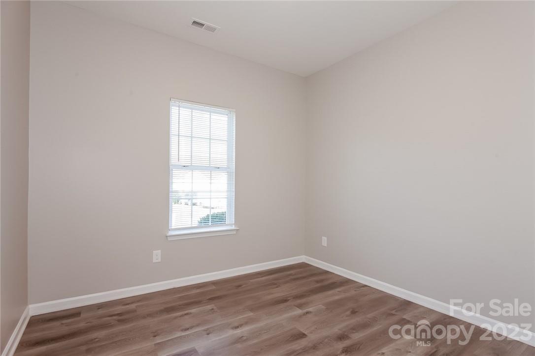 8215 Pozzi Road Charlotte, NC 28216 - Photo 8 of 15 an empty room with wooden floor and windows