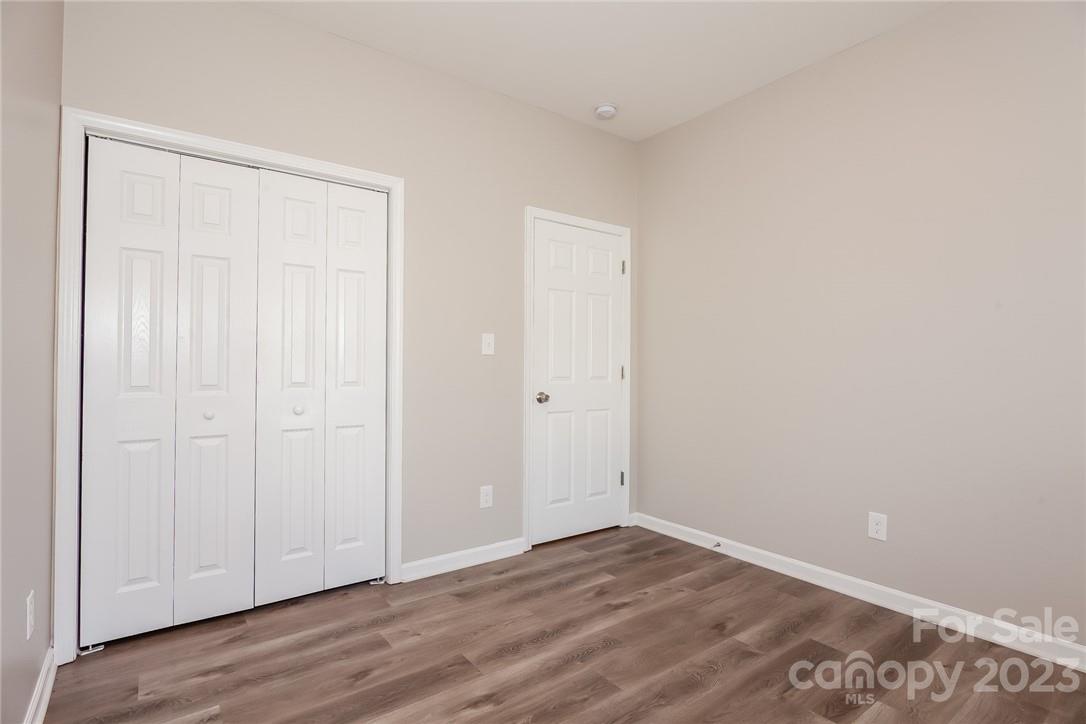 8215 Pozzi Road Charlotte, NC 28216 - Photo 9 of 15 a view of an empty room with wooden floor
