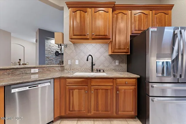 a kitchen with stainless steel appliances granite countertop a stove a sink and a microwave