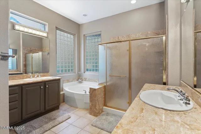 a bathroom with a granite countertop tub sink and mirror