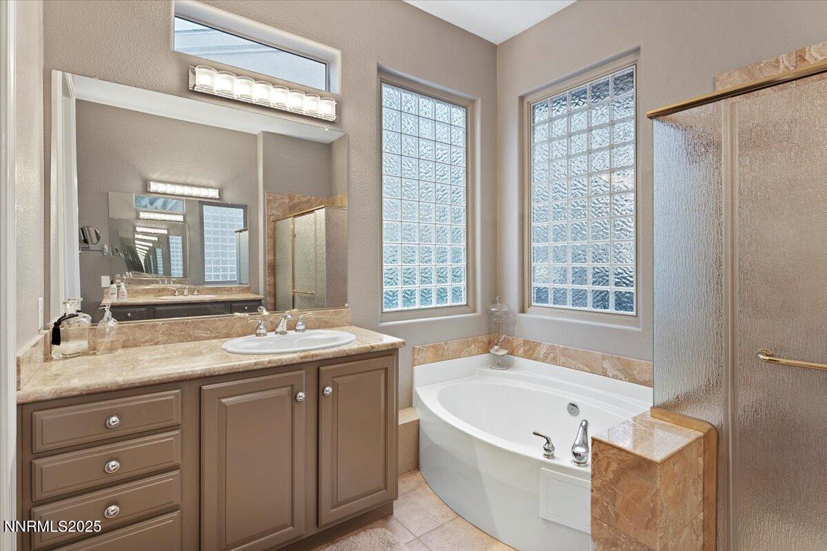 9900 Wilbur May Parkway, Unit 602 Reno, NV 89521 - Photo 23 of 32 a bathroom with a granite countertop tub sink and mirror