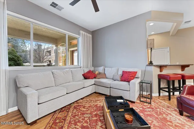 a living room with furniture a flat screen tv and a refrigerator