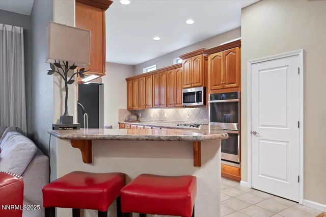 a kitchen with stainless steel appliances granite countertop a refrigerator and a sink