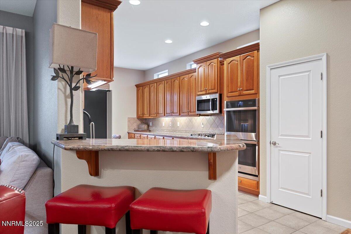 9900 Wilbur May Parkway, Unit 602 Reno, NV 89521 - Photo 10 of 32 a kitchen with kitchen island granite countertop a sink cabinets and window