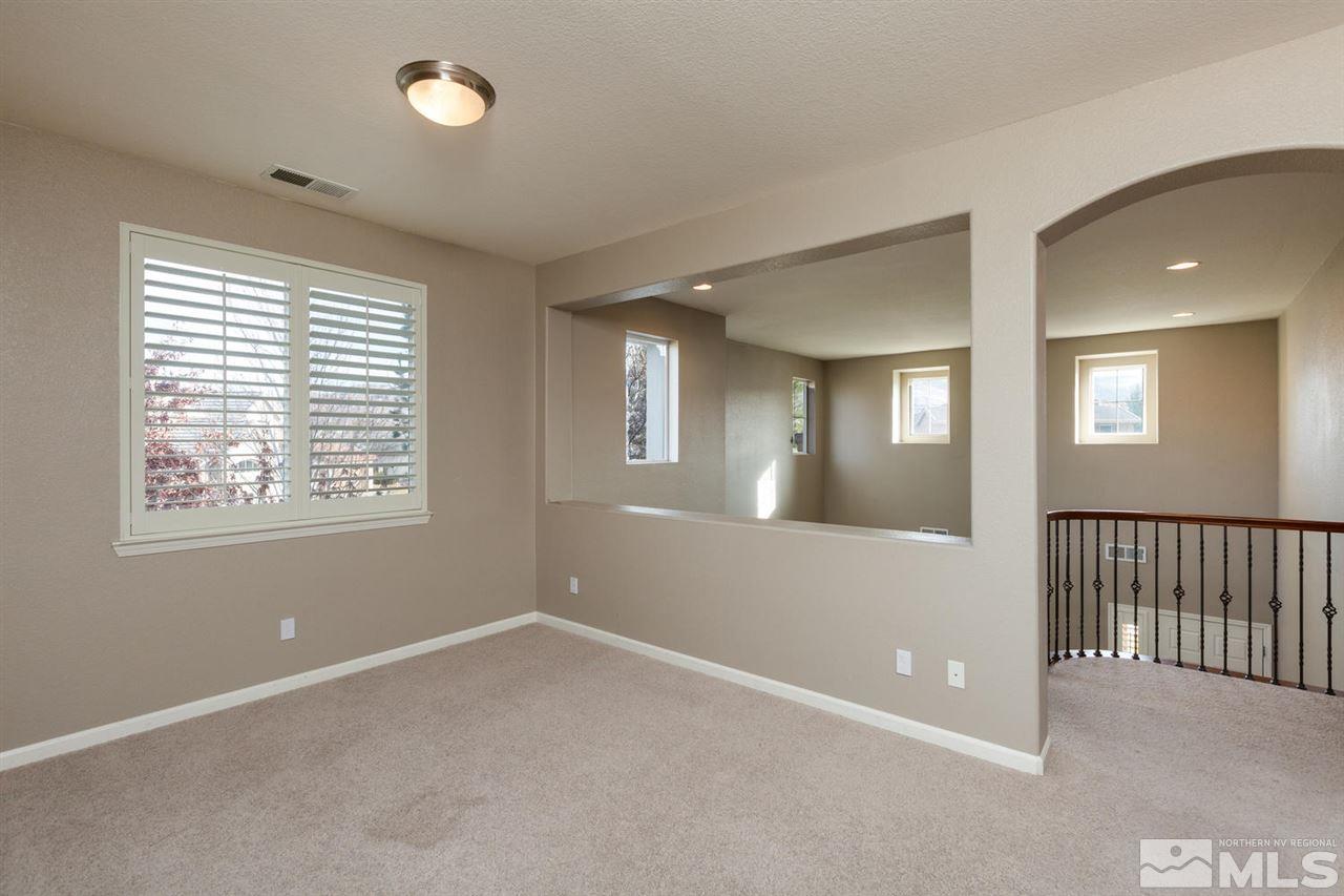 14005 Traveler Court Reno, NV 89521 - Photo 16 of 25 a view of an empty room with wooden floor and a window