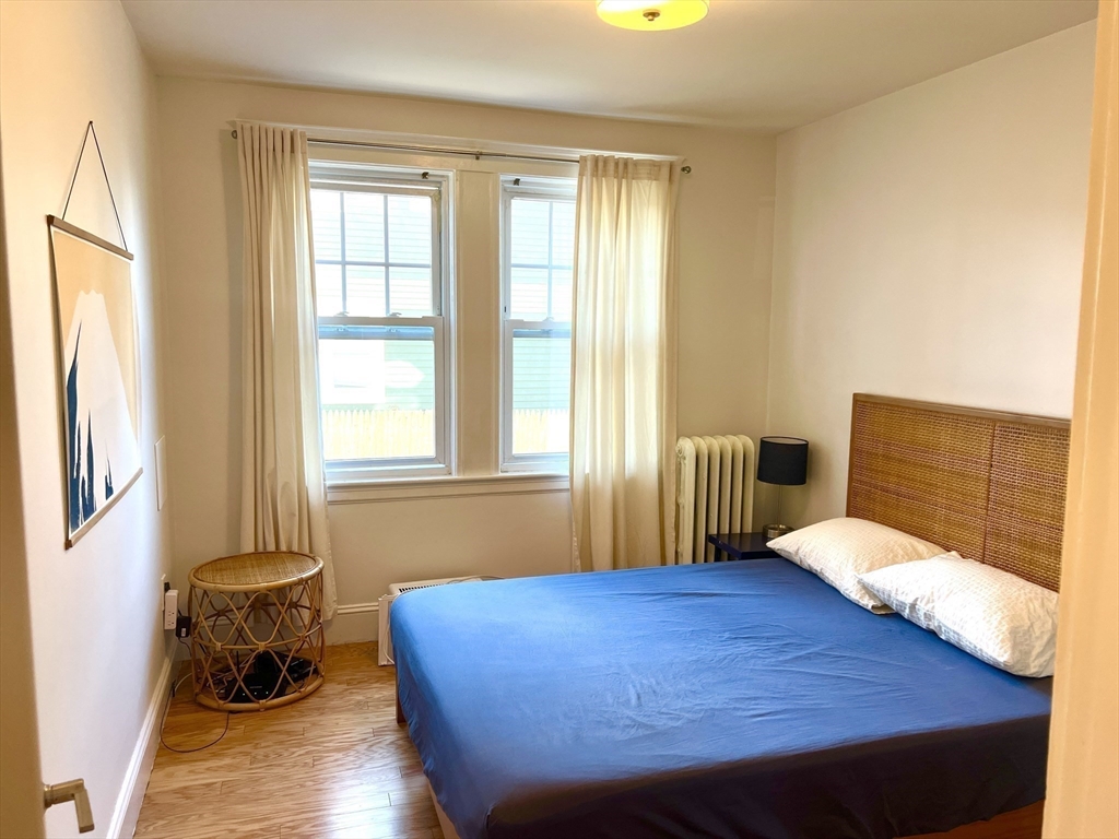 52 Ralph Street, Unit 52 Watertown, MA 02472 - Photo 11 of 17 a bedroom with a bed and wooden floor