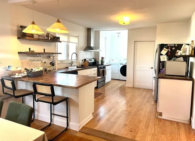a kitchen with a table chairs refrigerator and cabinets