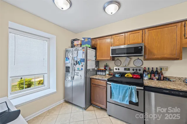 a kitchen with stainless steel appliances granite countertop a refrigerator sink and stove