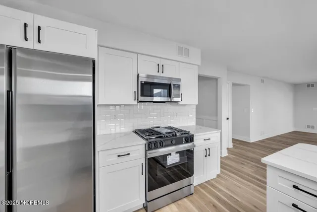 a kitchen with cabinets and steel appliances