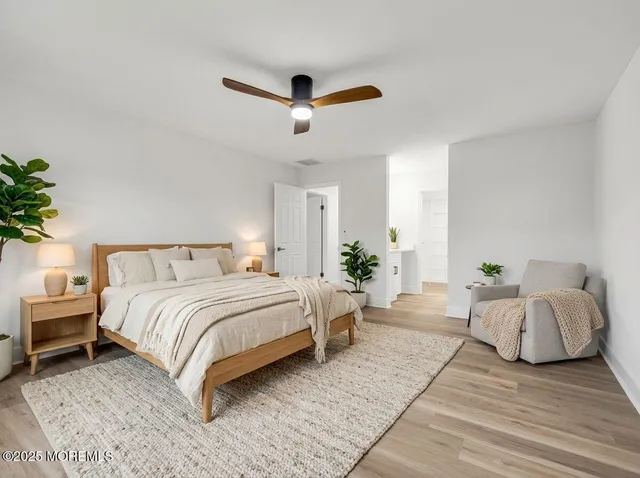 a spacious bedroom with a bed and a potted plant