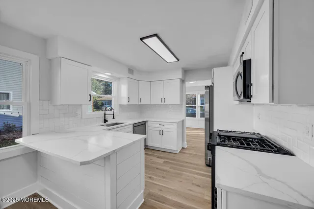 a kitchen with white cabinets and appliances