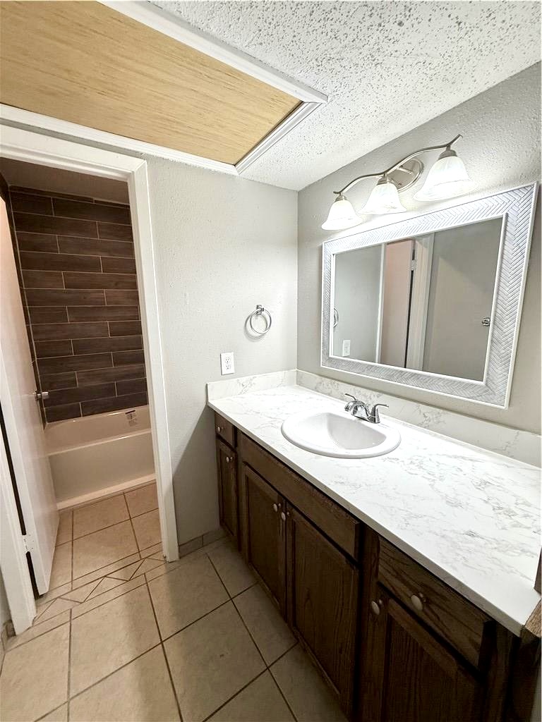 2000 Kazmeier, Unit 29 Bryan, TX 77802 - Photo 9 of 11 a bathroom with a granite countertop sink a mirror and a bathtub