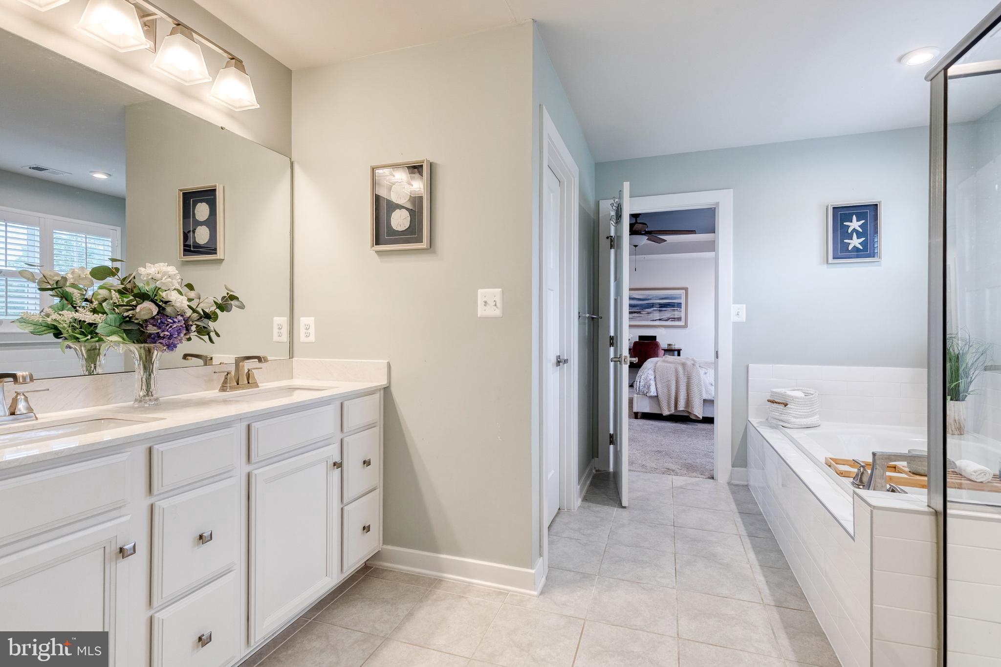 6003 Valentine Way Hanover, MD 21076 - Photo 35 of 52 a en suite bathroom with a double vanity sink a mirror and a shower