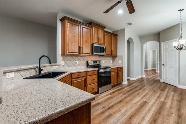 a kitchen with stainless steel appliances granite countertop a sink stove and refrigerator