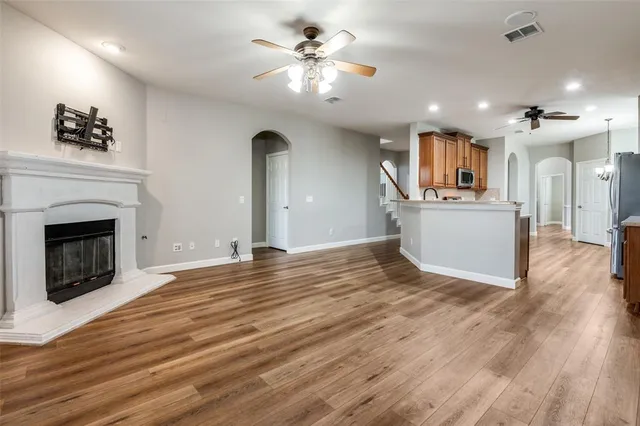 a view of a kitchen with a sink a fireplace and wooden floor