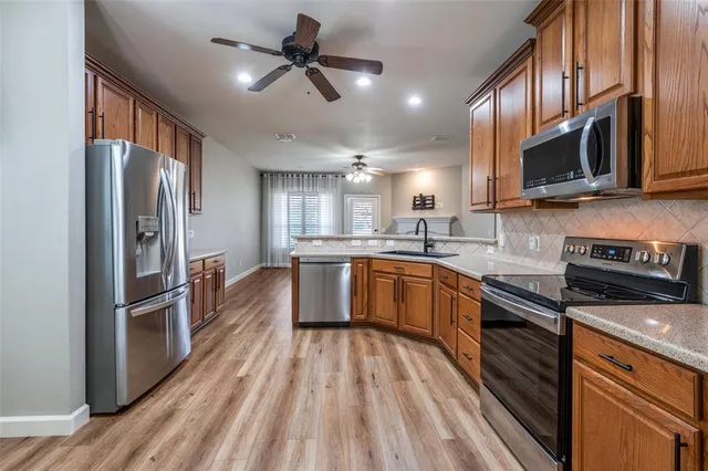 a kitchen with stainless steel appliances granite countertop a refrigerator a stove top oven a sink and dishwasher