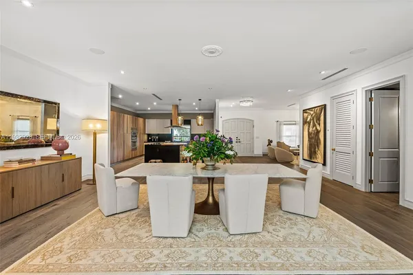 a kitchen with stainless steel appliances granite countertop a stove a sink dishwasher and a dining table with wooden cabinet