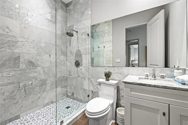 a bathroom with a sink a toilet and shower