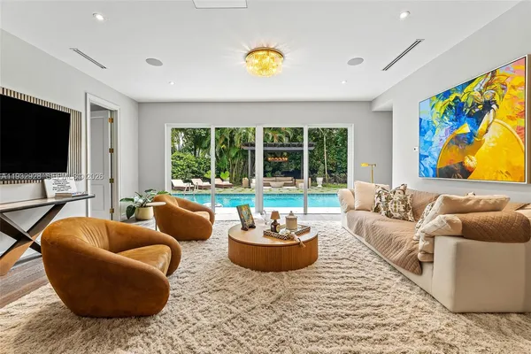a living room with furniture a flat screen tv and a large window