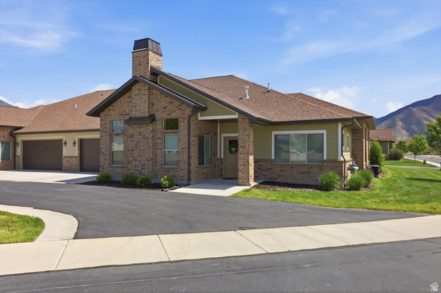 1838 West 300th Street South, Unit B Mapleton, UT 84664 - Photo 34 of 51 Brick and siding exterior featuring a prominent chimney, a covered entryway, and multiple large windows
