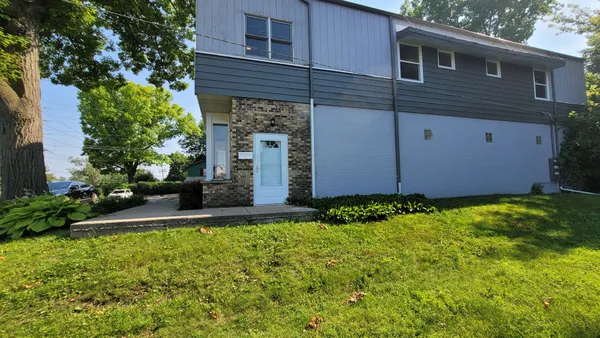 a view of a backyard with potted plants and large tree