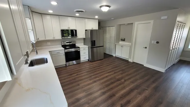 a kitchen with stainless steel appliances a refrigerator sink and microwave
