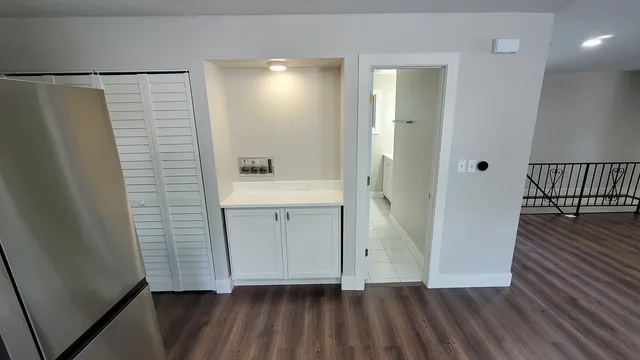 a view of a hallway with wooden floor and staircase