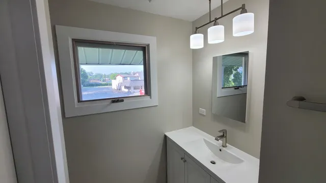 a bathroom with a sink mirror and vanity