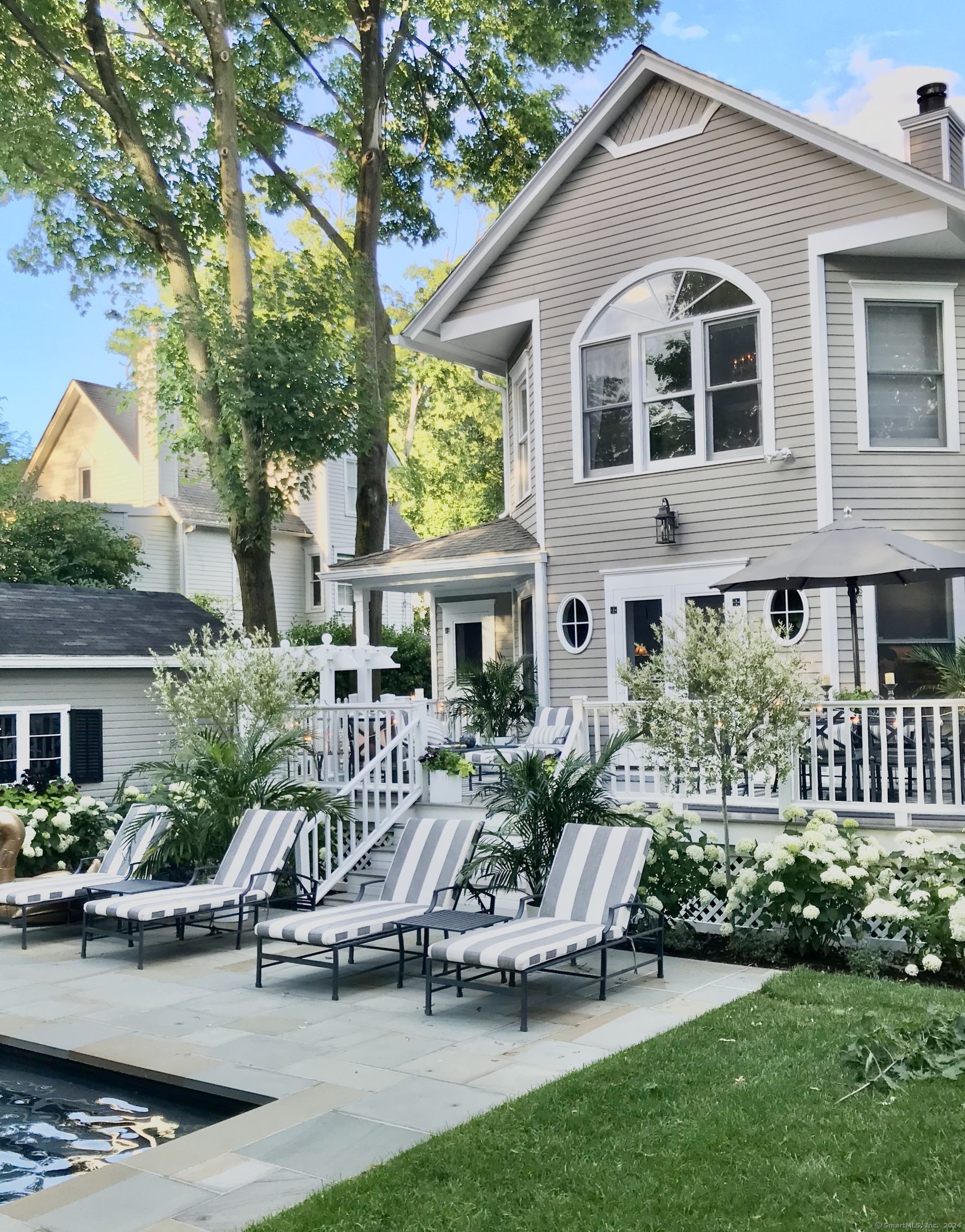 233 Rowayton Avenue Norwalk, CT 06853 - Photo 3 of 33 a front view of a house with a yard table and chairs