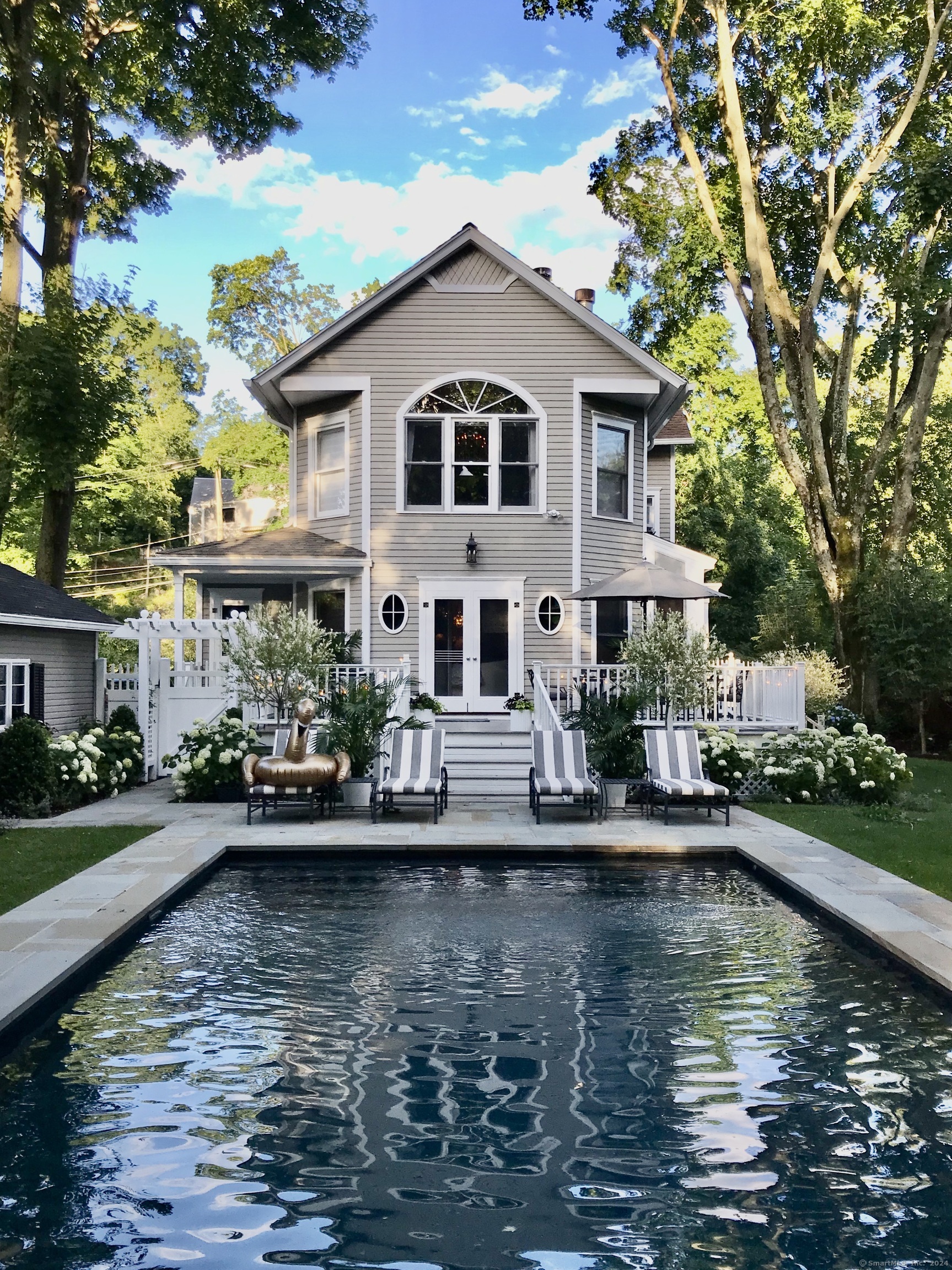 233 Rowayton Avenue Norwalk, CT 06853 - Photo 4 of 33 a white house with large pool plants and large trees