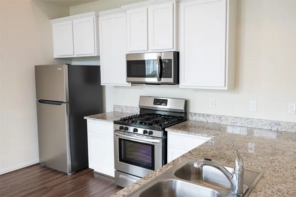 a kitchen with stainless steel appliances a stove a microwave and a refrigerator
