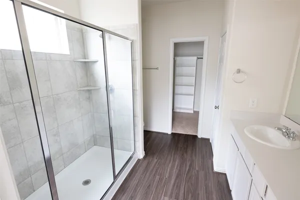 a bathroom with a sink and a glass door shower