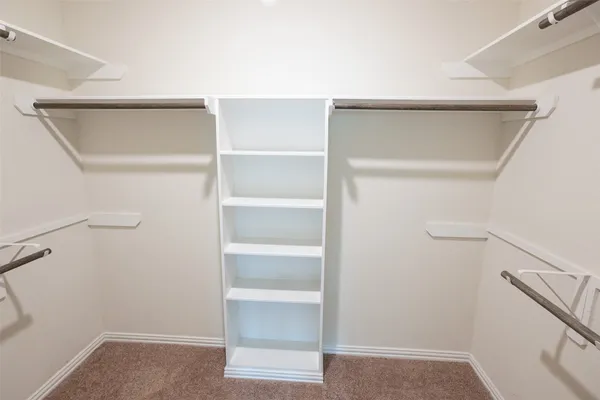 a view of walk in closet with empty racks