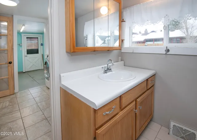 a view of an empty room with wooden floor and a cabinet