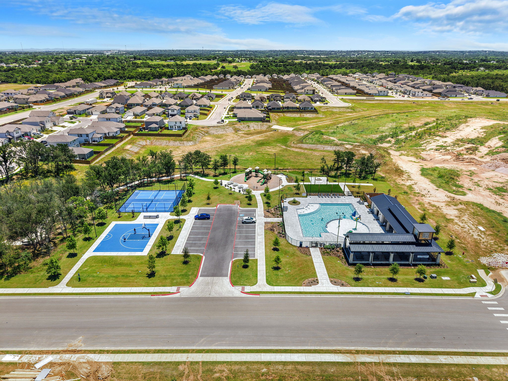 148 Hidalgo Lane Elgin, TX 78621 - Photo 5 of 38 An aerial perspective showcases a vibrant community with recreational courts and a welcoming pool area.