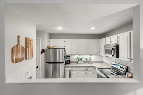 a kitchen with white cabinets and stainless steel appliances