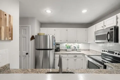 a kitchen with stainless steel appliances granite countertop a refrigerator stove a sink and dishwasher