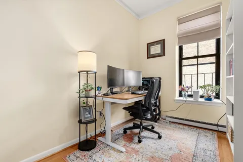 a view of a workspace with furniture and a window