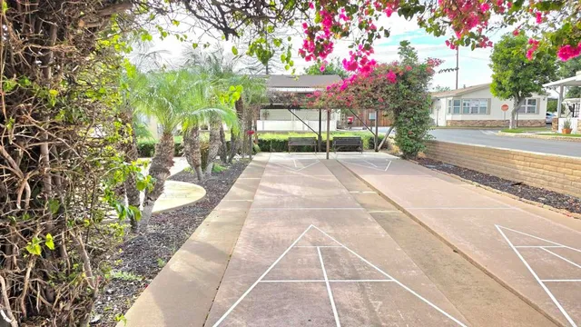 a view of a backyard with flowers and a bench