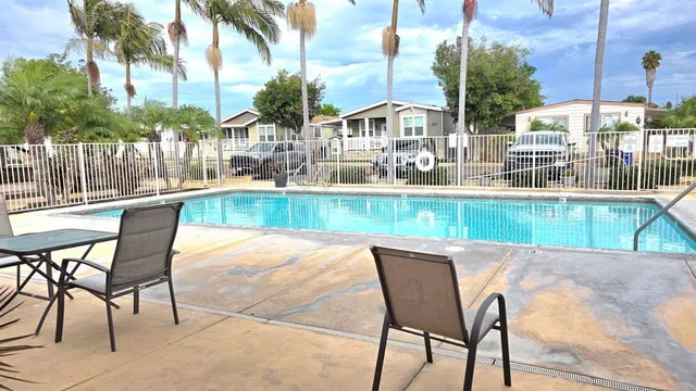 a patio with table and chairs and potted plants