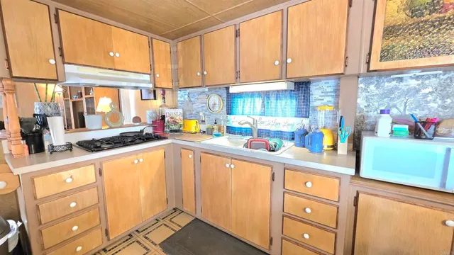 a kitchen with granite countertop a sink a stove and cabinets