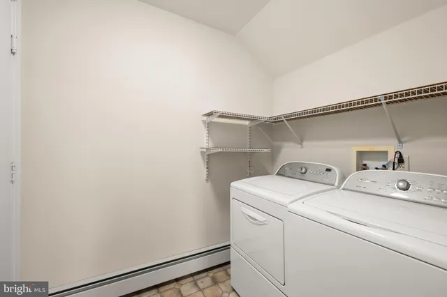 a view of a white house with a big yard and large trees