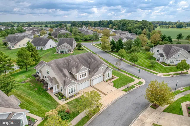 an aerial view of ocean and residential houses with outdoor space